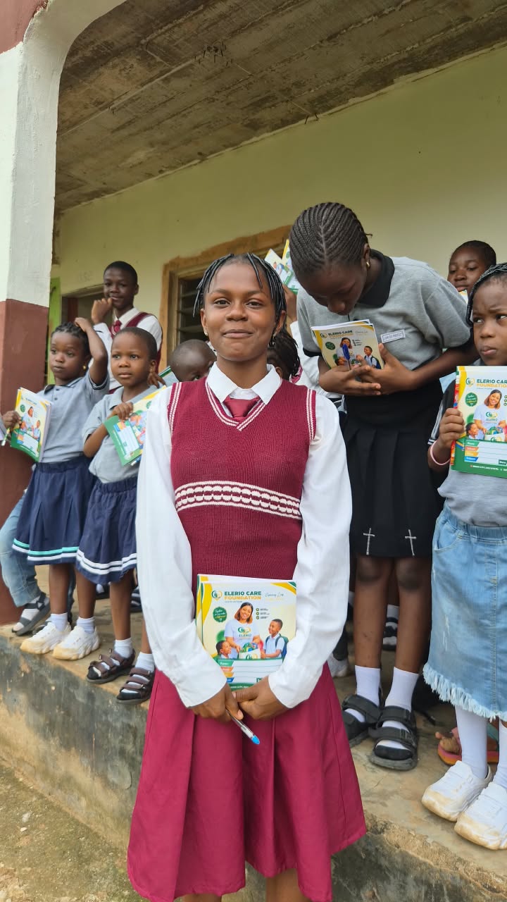 A student standing proudly with learning materials